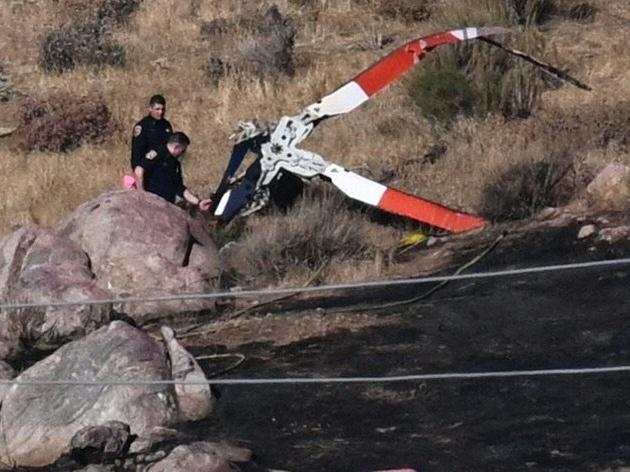 Investigators walk around rotor blades from a crashed helicopter on a burned hillside in Cabazon, Calif., on Monday, Aug. 7, 2023. Three people were killed when their helicopter crashed into a hillside after colliding with another chopper as the team battled a wildfire, emergency officials said. (Photo by Patrick T. Fallon / AFP via Getty Images)