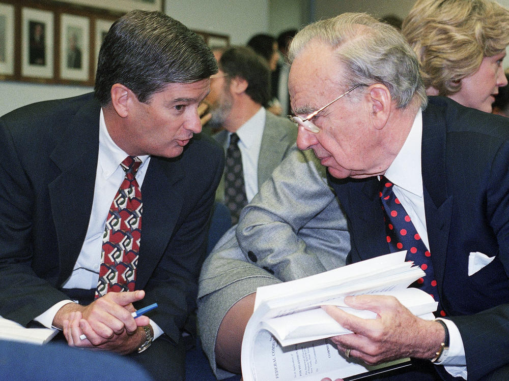 Media magnate Rupert Murdoch, right, huddles with Preston Padden, president of network distribution for Fox, during a hearing of the Federal Communications Commission in May 1995. A generation later, Padden says Murdoch is unfit to hold the licenses for local television stations due to Fox News.