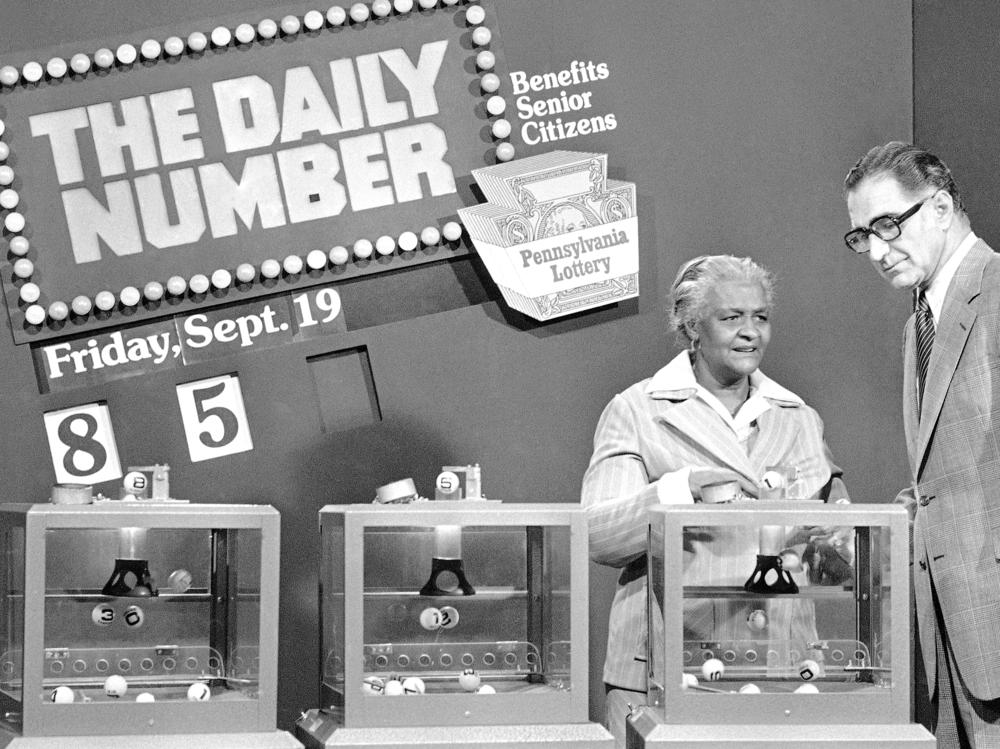 Pennsylvania citizen Mary Ann Gilliam, left, is aided by Pennsylvania Lottery district manager Peter H. Cardiges as she picks a number for a lottery drawing on Sept. 19, 1980 in Pittsburgh.