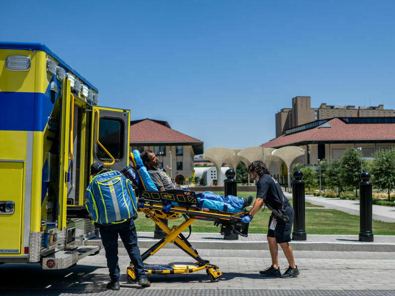 EMTs help a patient in Austin, Texas, this week. The man had passed out near the state capitol and was dehydrated. Cities with few trees and areas of shade are hotter during heat waves.