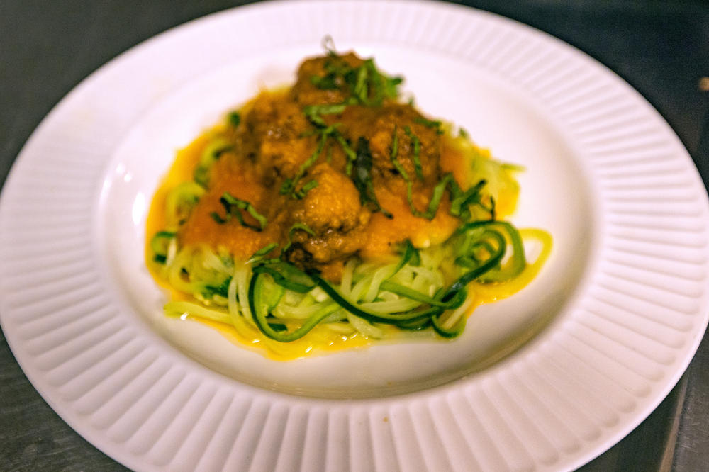 Zucchini pasta and soy-based meatballs with roasted tomato and shallot coulis.