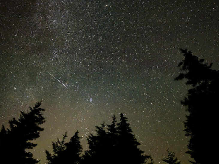 In this 30 second exposure, a meteor streaks across the sky during the annual Perseid meteor shower, Wednesday, Aug. 11, 2021, in Spruce Knob, West Virginia.