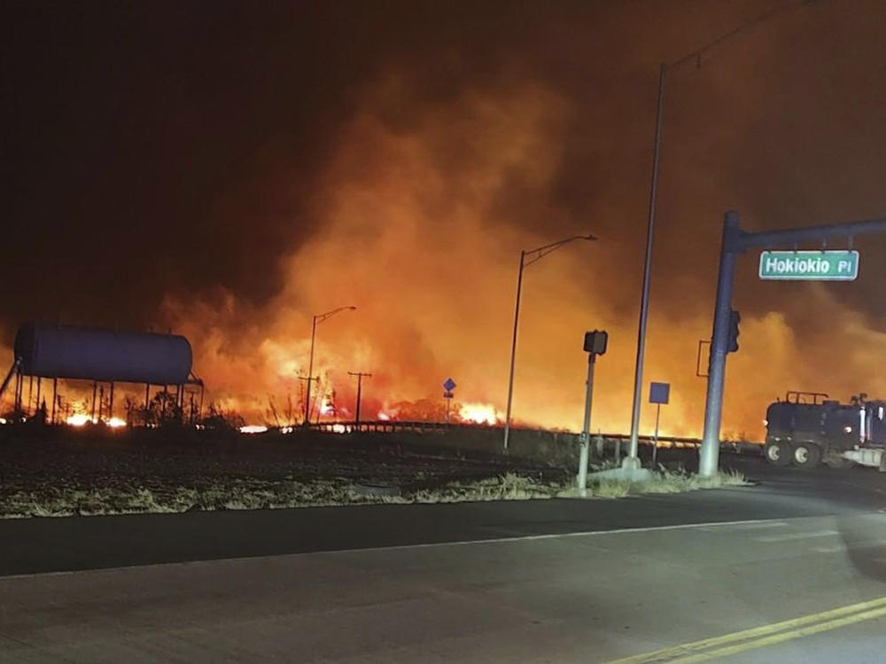 This photo provided by County of Maui shows fire and smoke filling the sky from wildfires on the intersection at Hokiokio Place and Lahaina Bypass in Maui, Hawaii on Tuesday.