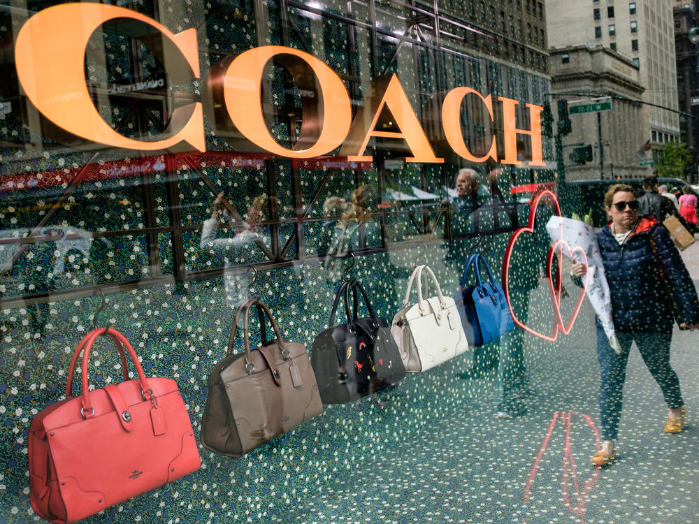 A woman walks past Coach bags in a store window in New York City in 2017.