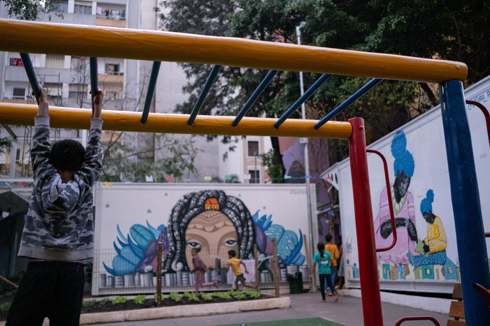 Children play among the dwellings established for unhoused families.