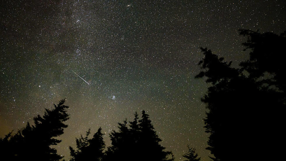 In this 30 second exposure, a meteor streaks across the sky during the annual Perseid meteor shower, Wednesday, Aug. 11, 2021, in Spruce Knob, West Virginia.