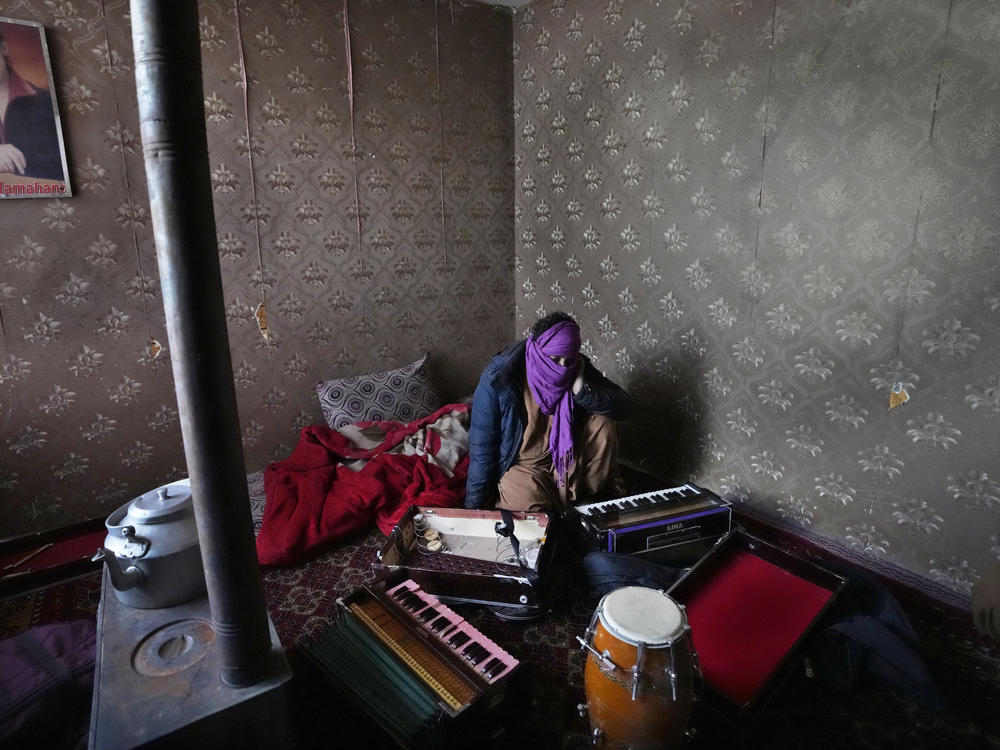 In 2022, a man in Kabul covered his face to protect his identity, as he showed his harmonium musical instrument. The Taliban have begun to burn these instruments, and others.