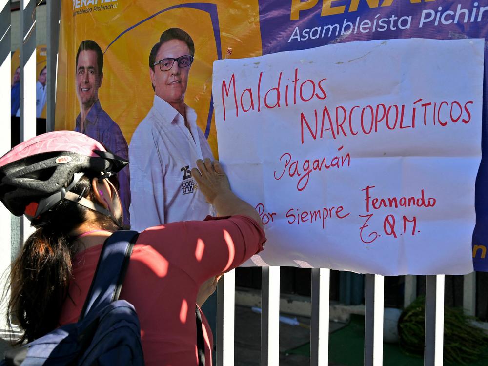 A cyclist hangs a placard against 