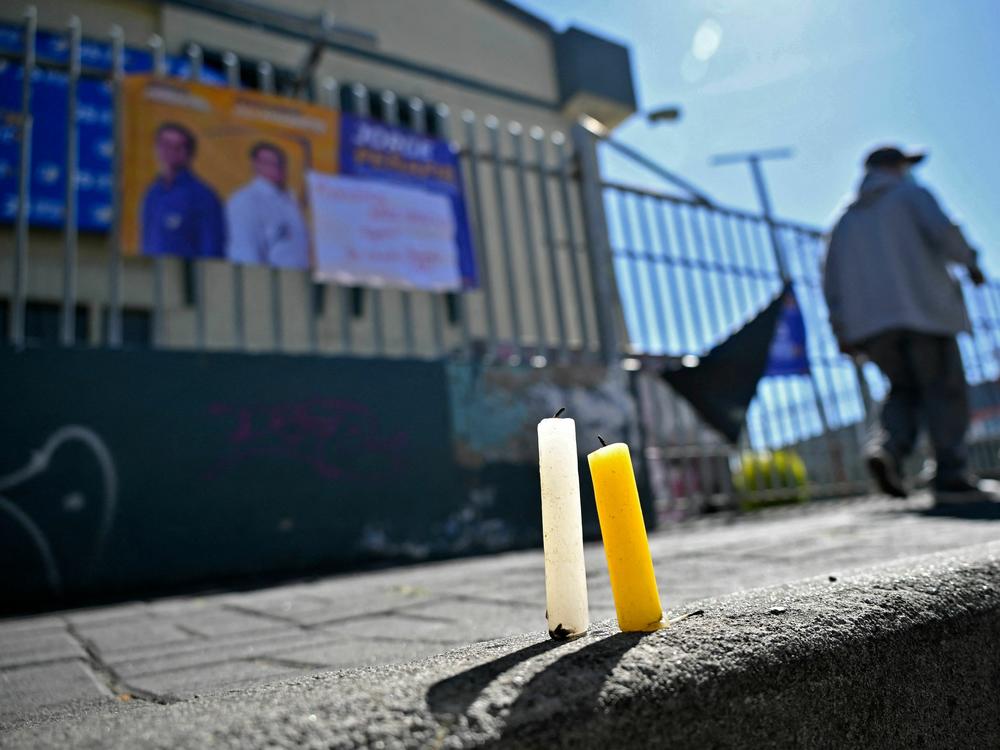 Candles are seen on the pavement outside the sports complex where Ecuadorian presidential candidate Fernando Villavicencio was assassinated in Quito.