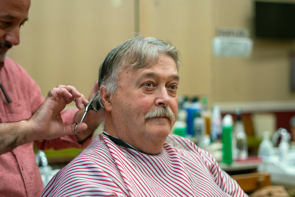 Charlie Barnholt talks to NPR while getting a haircut at Uncle Joe's Barbershop in Martinsburg, West Virginia.