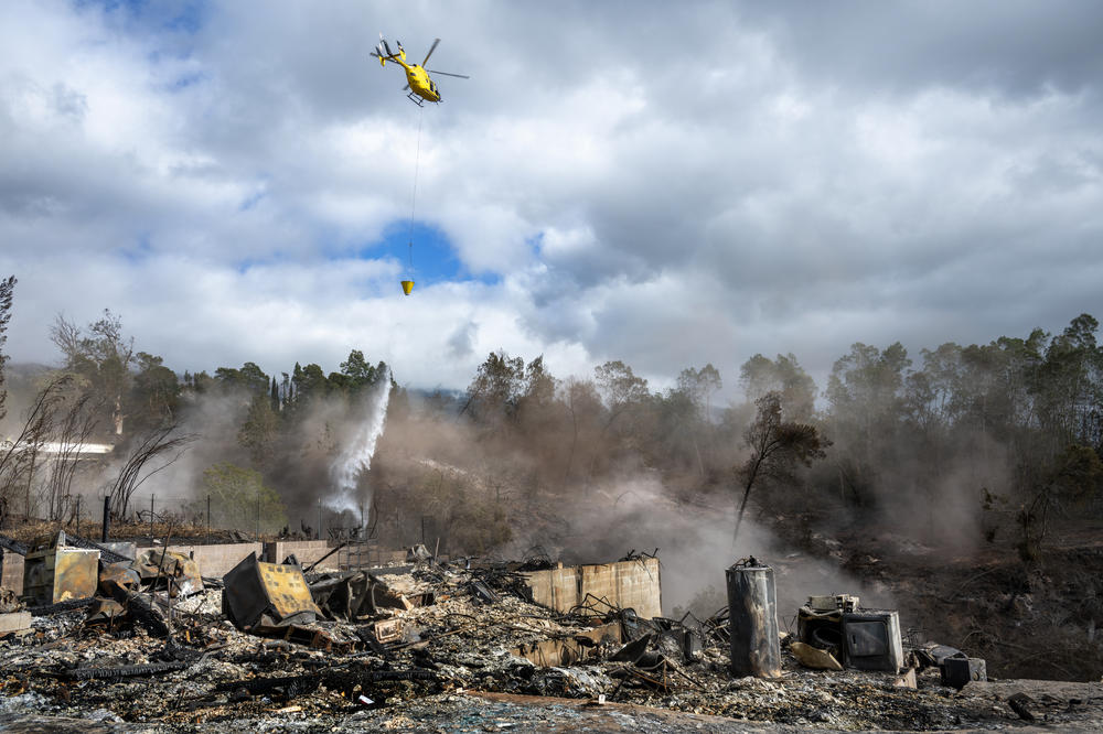 A helicopter makes a pass over the Kula wildfire area in upcountry Maui.
