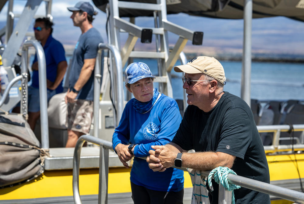 John Picard, right, talks to Jennifer Kogan. Kogan, center, offered to give Picard and his wife a boat ride to Lahaina to be reunited with their daughter since they are unable to drive on the closed road to Lahaina.