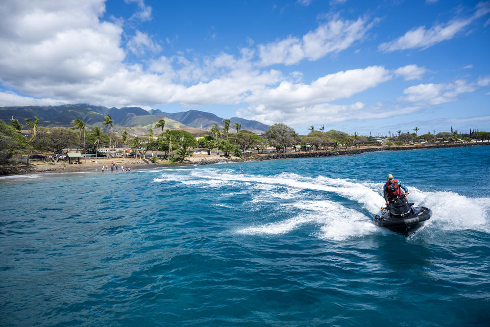 The local surfing community are shuttling donated items on jet boats from large boats to the shore in Lahaina.