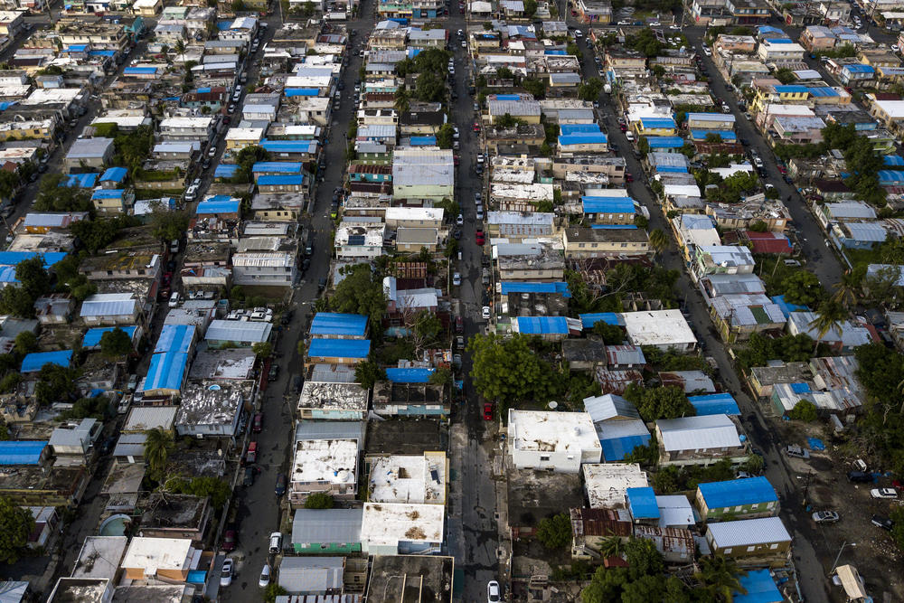 A year after Hurricane Maria slammed ashore in Puerto Rico, buildings in San Juan still relied on temporary blue roof tarps provided by the federal government. For many Puerto Rican children, compounded trauma from multiple natural disasters lingers.