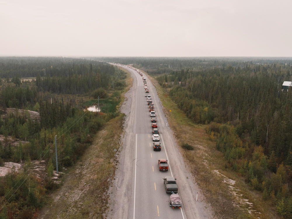 Residents flee Yellowknife, Canada, on Highway 3 after being ordered to evacuate on Wednesday due to a wildfire heading closer to the city.