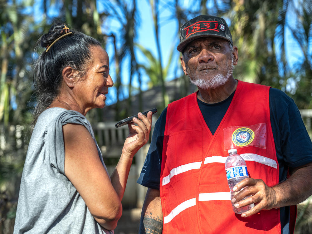 Uilani (left) and Keeamoku Kapu run the Na 'Aikane o Maui Cultural and Research Center which was burned to the ground in the wildfires so they set up this grassroots community distribution center in Lahaina. They are on the phone here taking a call from Oprah about supplies she will be delivering.