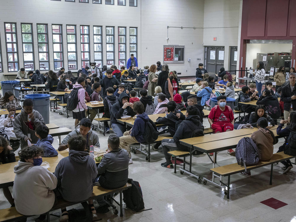 Students eat lunch in the cafeteria at Tonalea K-8 school in Scottsdale, Ariz., on Dec. 12, 2022. In Massachusetts, a new 4% state income tax on incomes above $1 million will help pay for free school lunches.