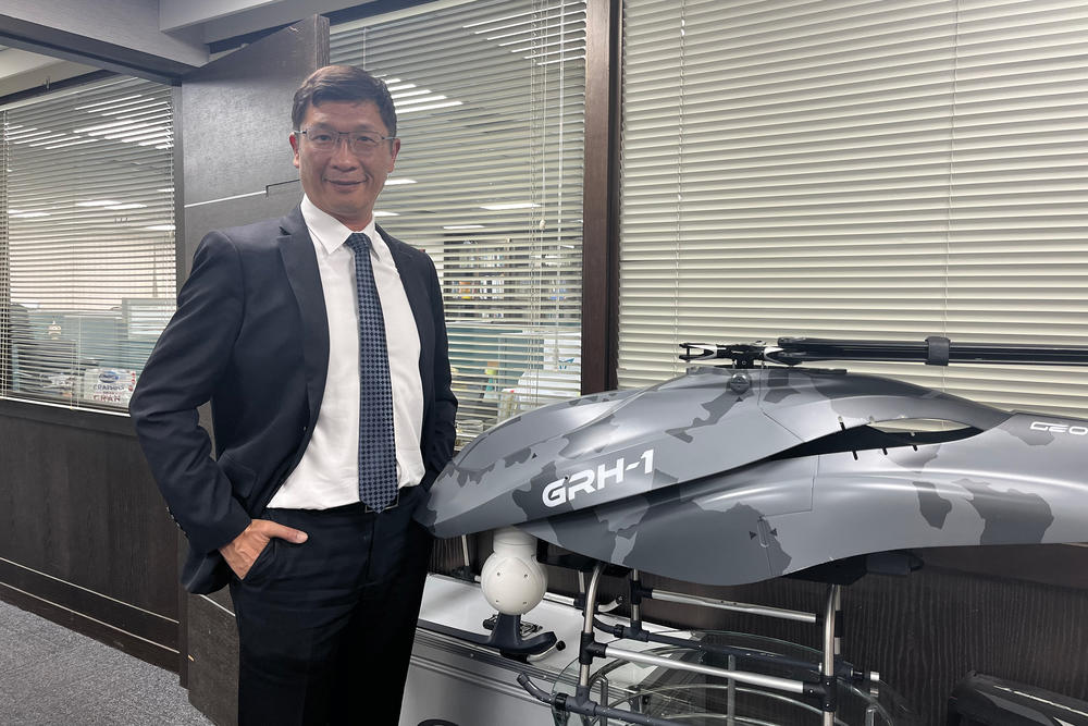 Lo Cheng-Fang, the founder of Geosat, poses for a portrait next to a tactical helicopter made by the drone company.