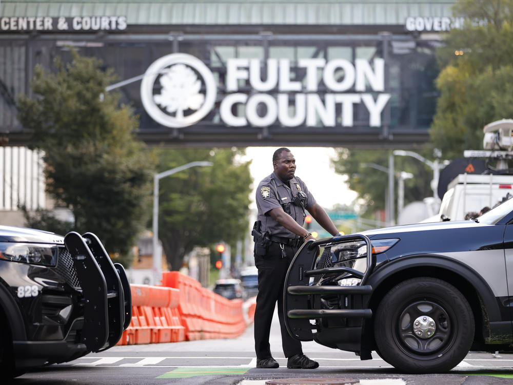 A sheriff's deputy stands guard near the Fulton County Courthouse in Atlanta on Monday. Authorities in Georgia said Thursday they're investigating threats targeting members of the grand jury that indicted former President Donald Trump and 18 of his allies.