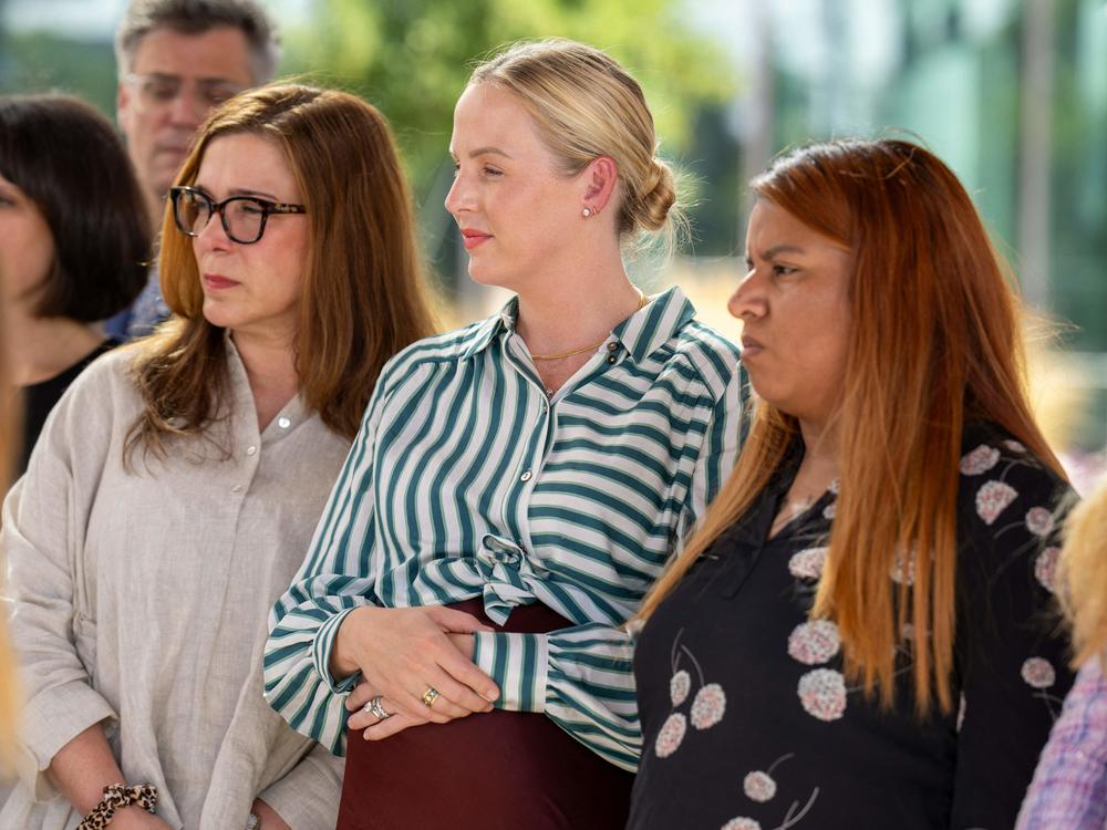 Dr. Austin Dennard, center, stands between fellow plaintiffs, Dr. Damla Karsan, left, and Samantha Casiano, outside a courthouse in Austin where their case was heard on July 20.