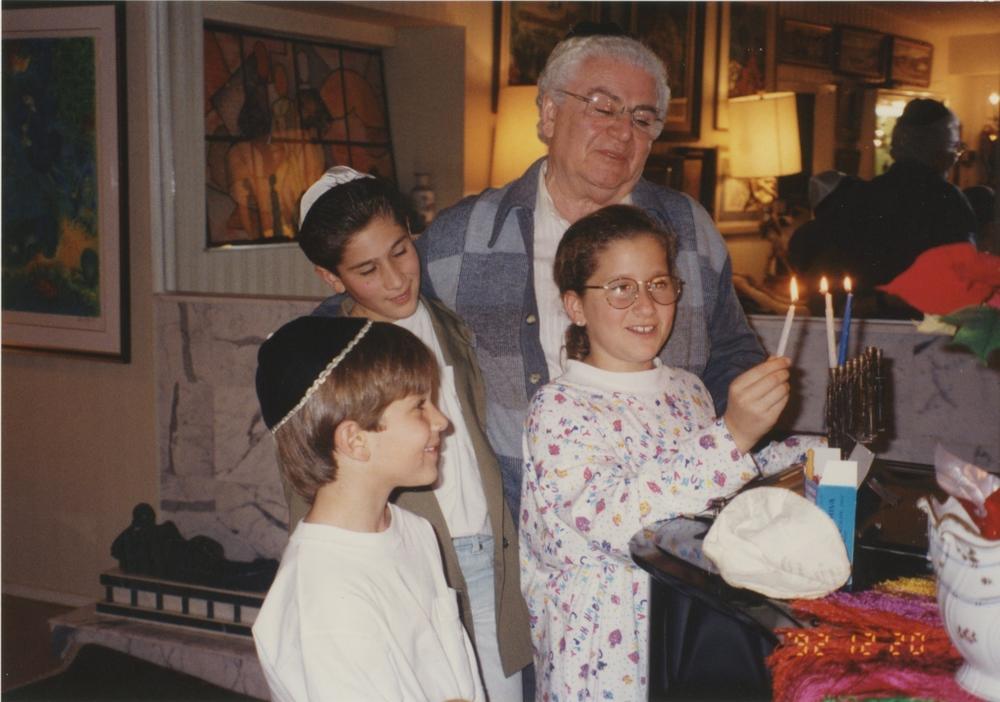 Zoltan and her brothers, David and Jonathan, during Hanukkah with her grandfather in the early 1990s.