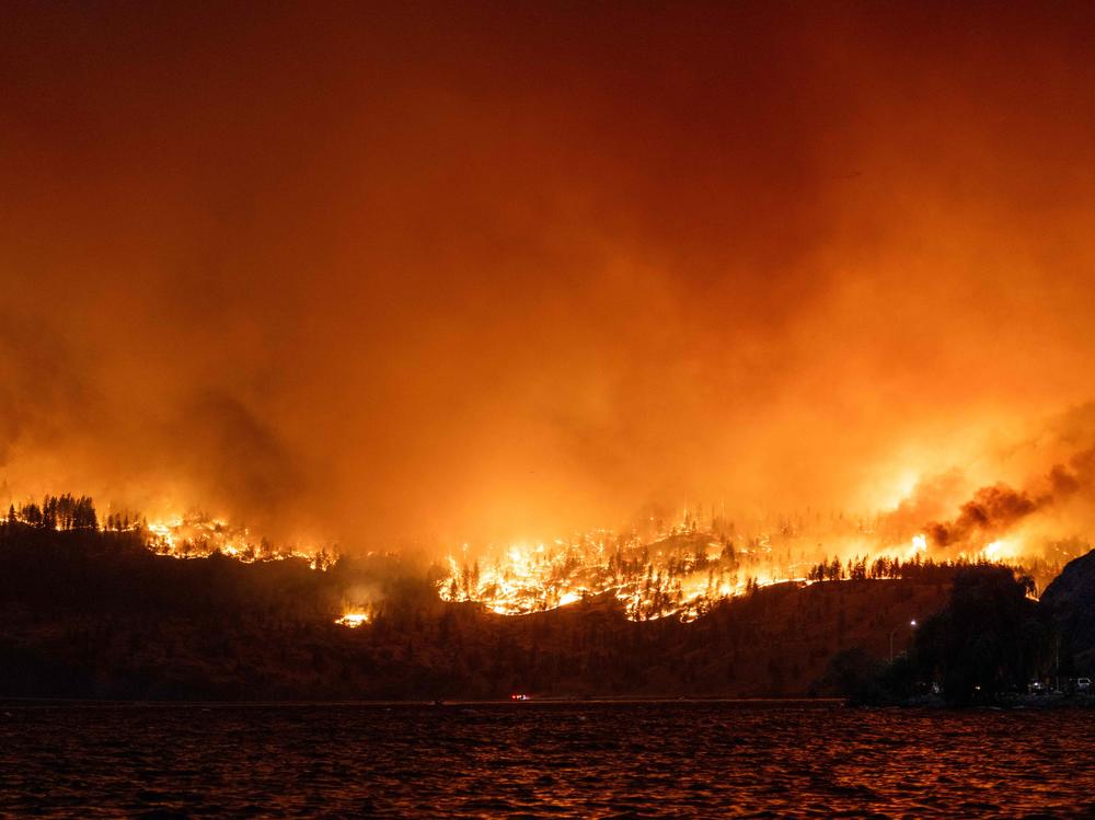 The McDougall Creek wildfire burns in the hills West Kelowna, British Columbia, Canada, on Thursday as seen from Kelowna.