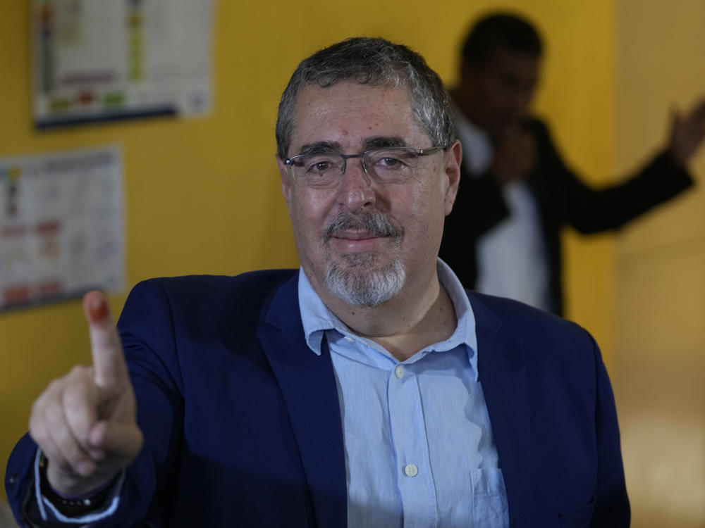 Bernardo Arevalo, presidential candidate with the Semilla Movement, shows his finger dyed with electoral ink after voting in the run-off presidential election in Guatemala City, Sunday, Aug. 20, 2023.