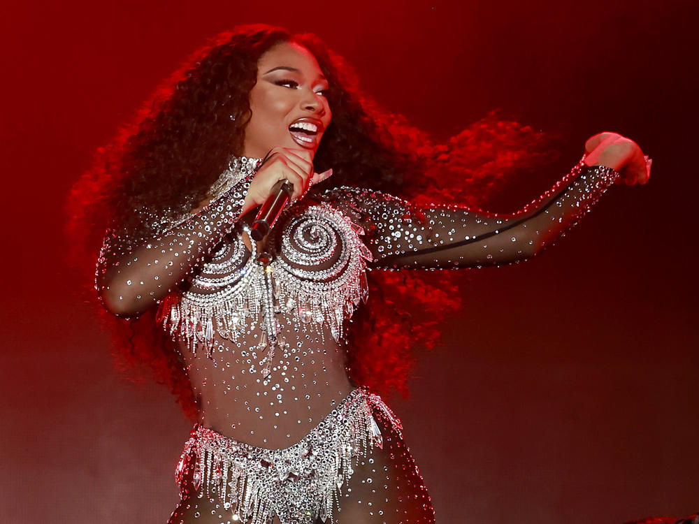Megan Thee Stallion performs onstage during the 2023 LA Pride in the Park Festival. In the first episode of its second season, the <em>Louder Than A Riot</em> podcast examines the backlash Megan faced after being shot by rapper Tory Lanez.