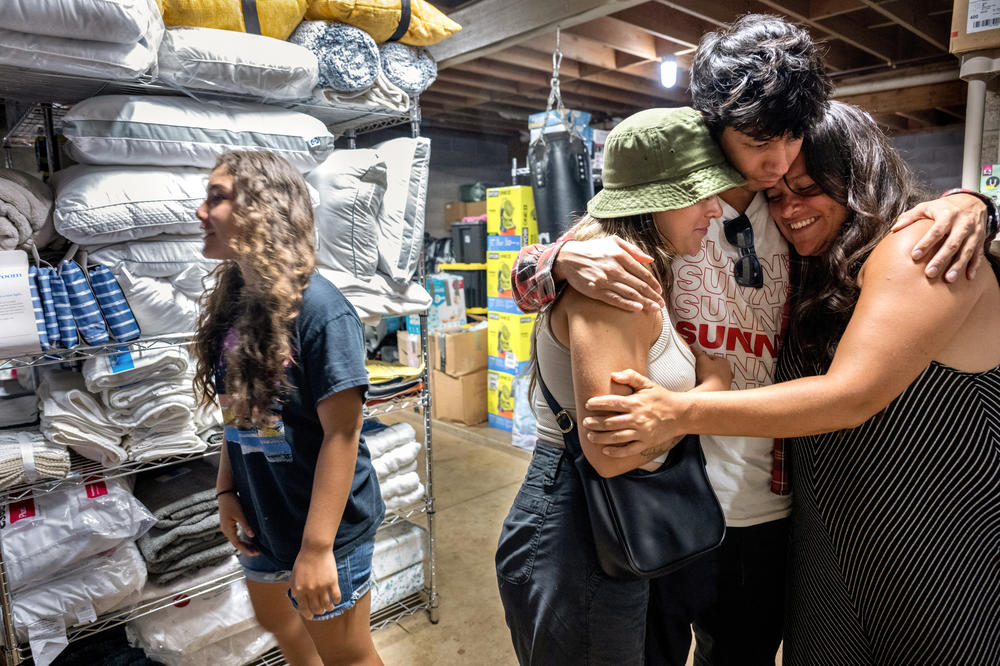 Zoë Miller, Max Louis and Haley Miller share a hug. Louis came from Oahu to help those who lost their homes in the wildfires.