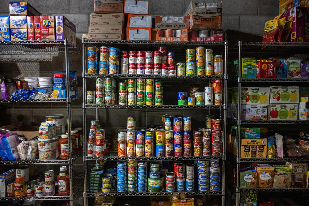 Supplies are stacked in shelves in a garage space at the property where dozens of displaced residents from Lahaina are staying.