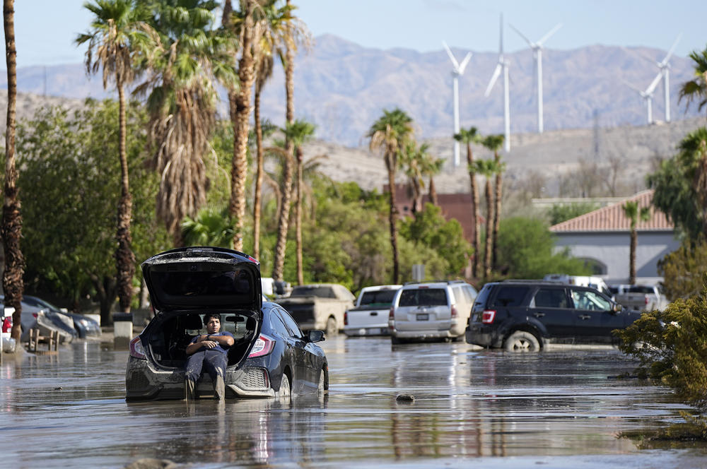 Mon., Aug. 23: Dorian Padilla sits in his car as he waits for a tow after it got stuck in the mud on a street in Cathedral City, Calif.
