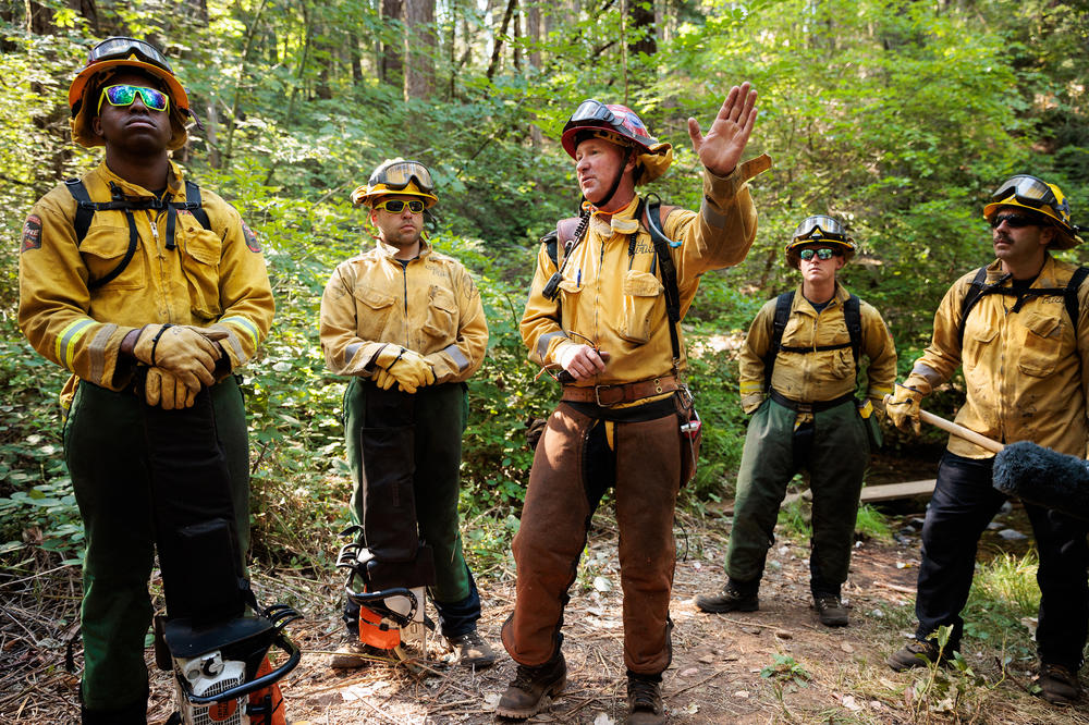 Cal Fire Captain Eric Ayers briefs members of the California National Guard's Task Force Rattlesnake before they spend the day clearing brush and small trees, all part of fire prevention tactics.