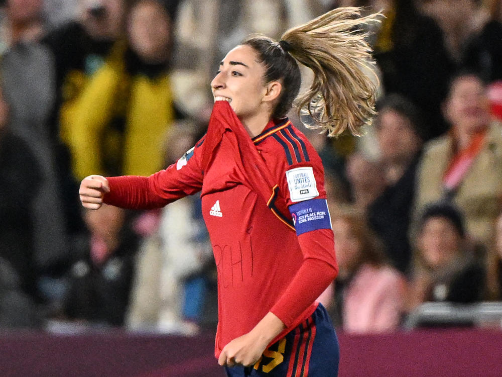 Spain's Olga Carmona points to the message she had written on her undershirt to honor the death of one of her best friend's mother after scoring what would be the only goal in the match against England on Sunday. Carmona later learned that her father had died before the final match.