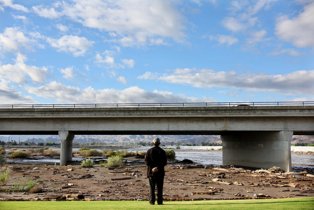 Mon., Aug. 21: A local resident surveys the damage where the normally dry Whitewater River flooded a golf course when Tropical Storm Hilary moved through the area o in Cathedral City, California.