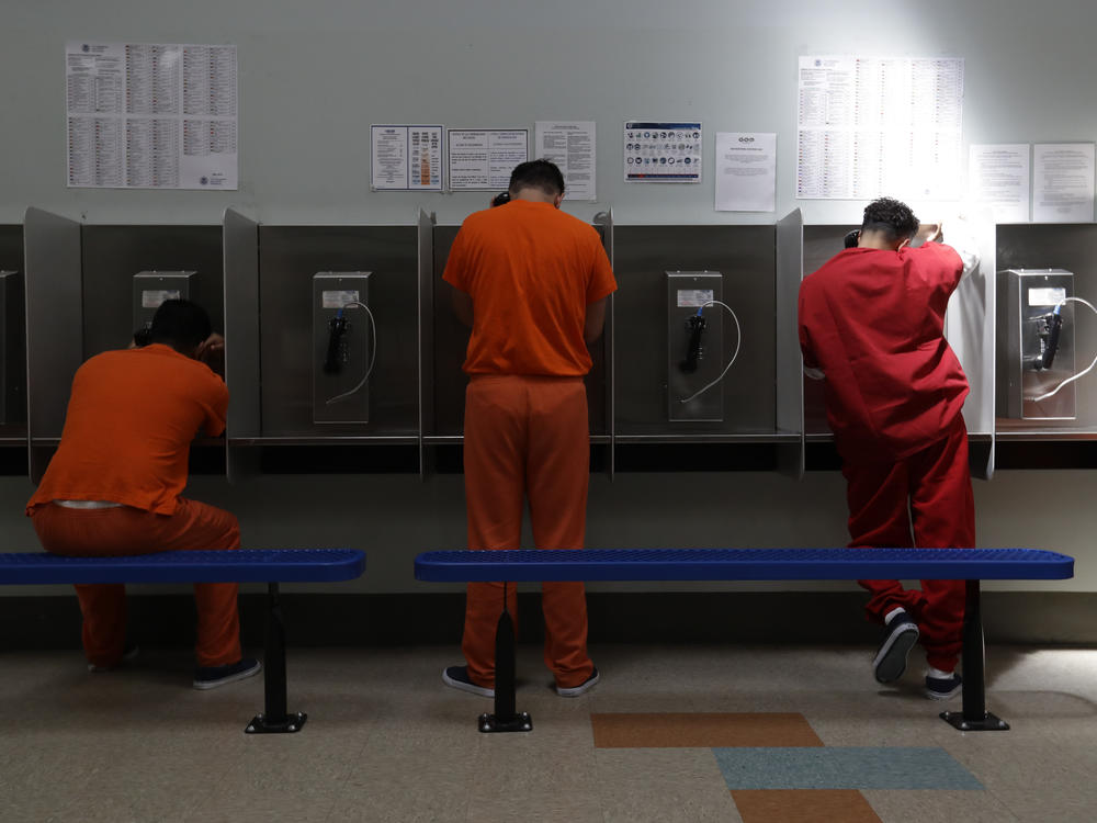 Immigrants in the custody of U.S. Immigration and Customs Enforcement (ICE) use the phones at a detention center in California in 2019. Secret government reports obtained by NPR described 