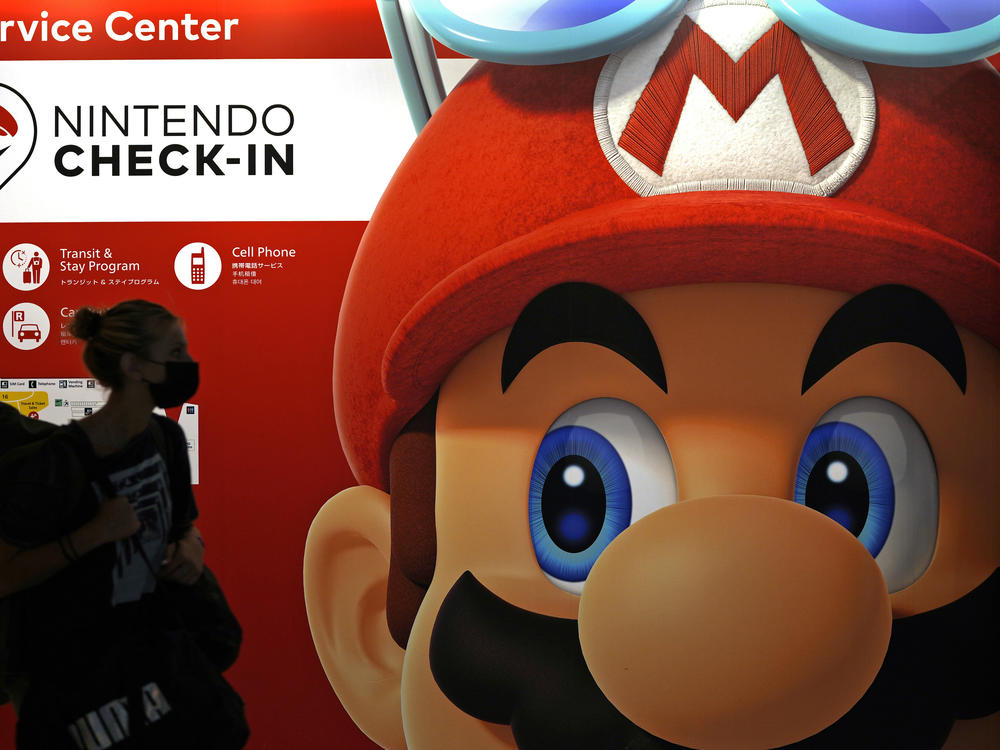 A person passes an ad featuring the Nintendo character Mario at Narita airport in Narita near Tokyo on June 10, 2022.
