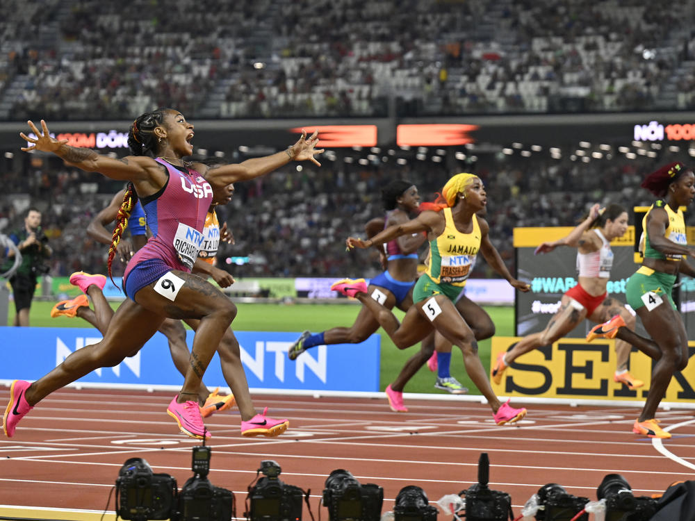 Sha'Carri Richardson, of the United States, spreads her arms as she crosses the line to win the women's 100-meter final during the World Athletics Championships in Budapest, Hungary.