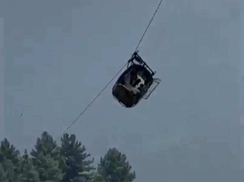 In this image taken from video, a cable car carrying six children and two adults dangles hundreds of feet above the ground in the remote Battagram district, Khyber Pakhtunkhwa, Pakistan, on Tuesday. The occupants were trapped for hours until they were freed by Pakistan Army commandos using helicopters and a makeshift chairlift.