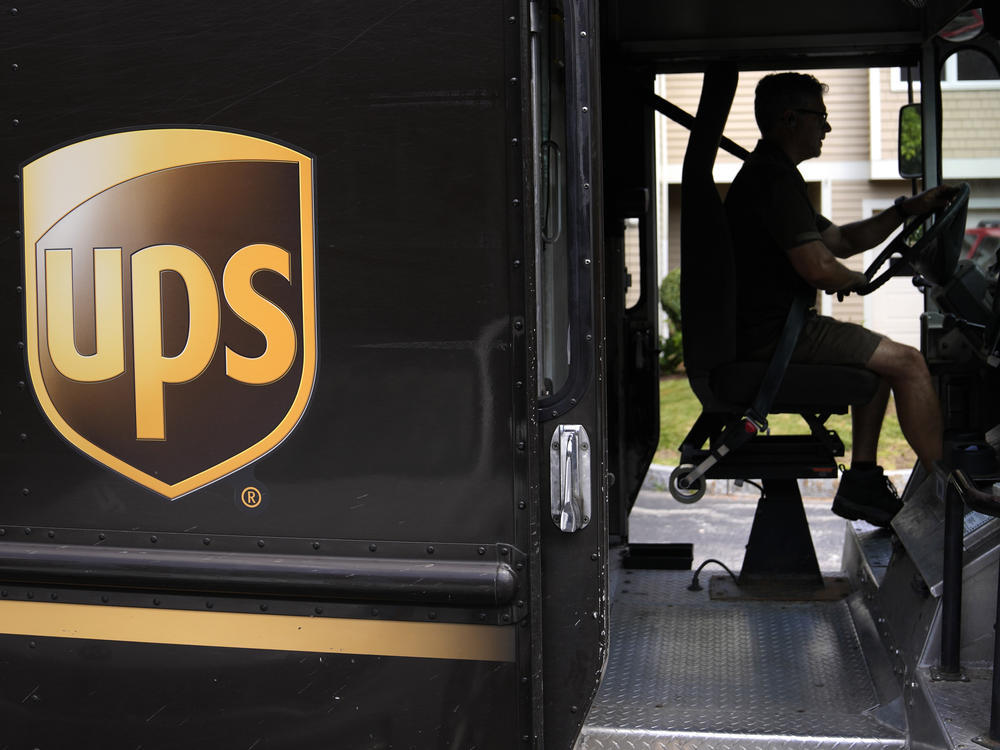 United Parcel Service driver Hudson de Almeida steers through a neighborhood while delivering packages, June 30, 2023, in Haverhill, Mass.