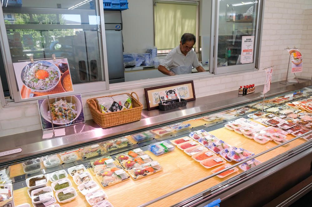 Takashi Nakajima prepares seafood in his supermarket.