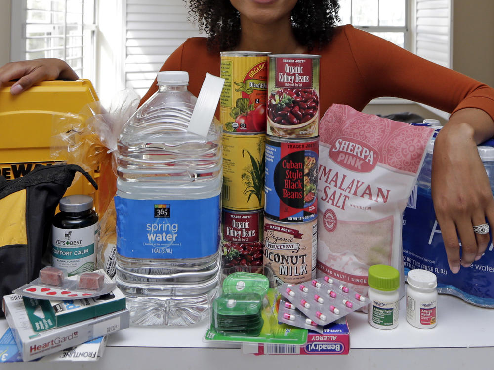 In this Friday, Sept. 29, 2017, photo, Lexi Montgomery poses with supplies she has purchased in the event of another storm, in Miami Beach, Fla. Hurricane Irma was the first hurricane that Montgomery ever experienced. (AP Photo/Alan Diaz)