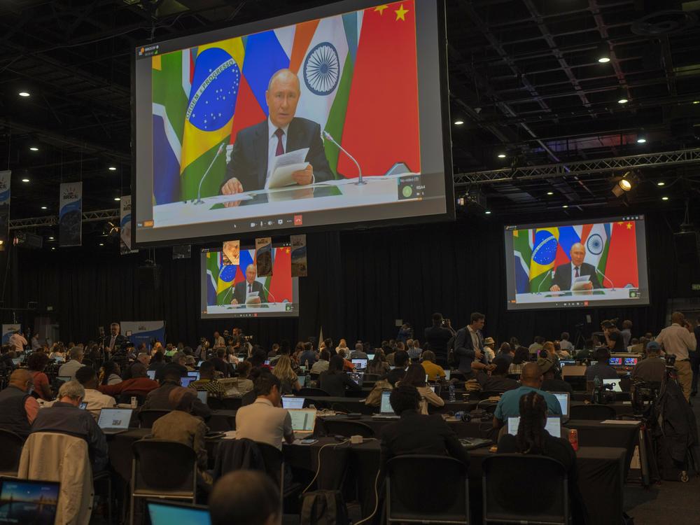 Members of the media watch Russia's President Vladimir Putin address via videolink the 2023 BRICS Summit in Johannesburg, South Africa, Wednesday, Aug. 23, 2023.