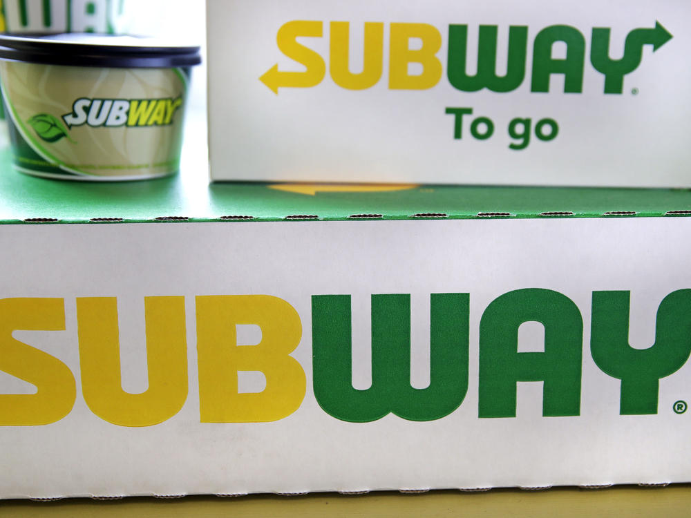 The Subway logo is seen on takeout boxes at a restaurant in Londonderry, N.H. The sandwich chain says it will be sold to the private equity firm Roark Capital. Terms of the deal weren't disclosed.