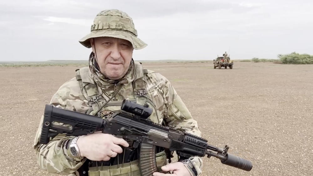 A screen grab captured from a video shared online shows Yevgeny Prigozhin, the founder of the Russian private security company Wagner, holding a rifle in a desert area while wearing camouflage in an unspecified location in Africa, Aug. 21.