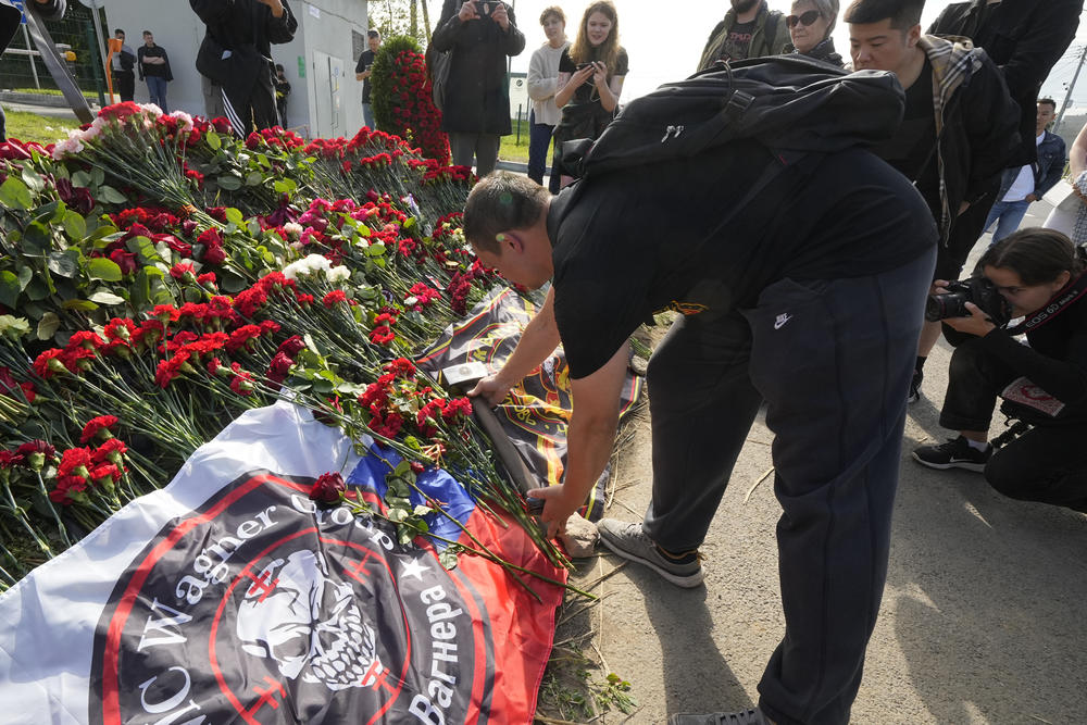 A fighter of the Wagner private military force places a sledgehammer, one of the Wagner symbols, at an informal memorial next to the former Wagner headquarters in St. Petersburg, Russia, Thursday.