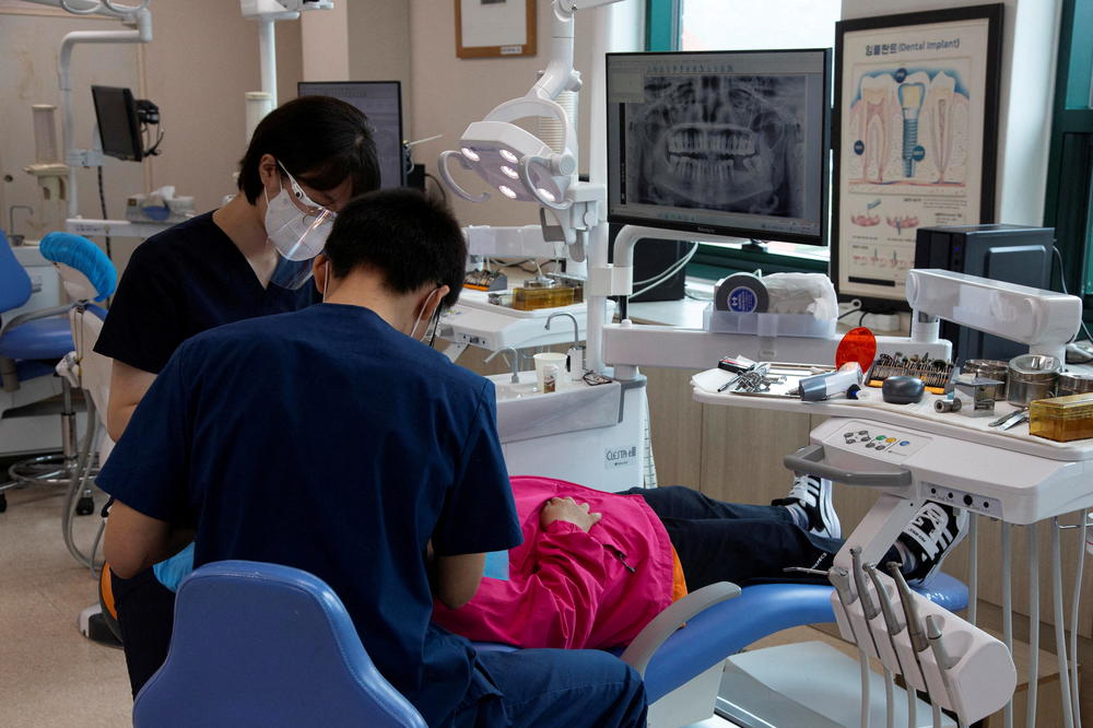 A North Korean defector (in red shirt) receives dental treatment at the Hanawon Settlement Support Center for North Korean Refugees in Ansong, South Korea, July 10.