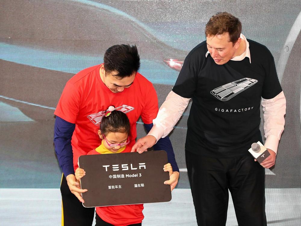 Tesla CEO Elon Musk gives a plaque to a child as buyers receive new cars during the Tesla China-made Model 3 Delivery Ceremony in Shanghai on Jan. 7, 2020. Companies like Tesla still see China as a key market as well as a production base.