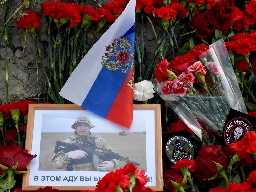 A portrait of Yevgeny Prigozhin is seen among flowers at a makeshift memorial in front of the Wagner Group headquarters in St. Petersburg, Friday. Prigozhin and other members of the mercenary company are believed to have died in a plane crash in Russia.