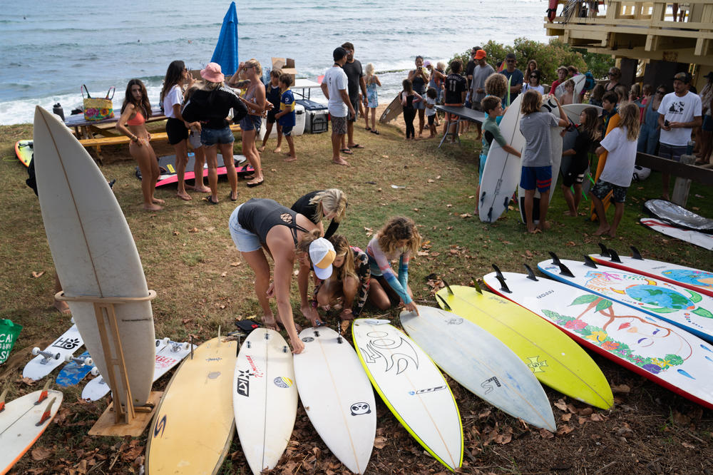 Alms and a group of kids look at the surfboards donated by Boards 4 Buddies.