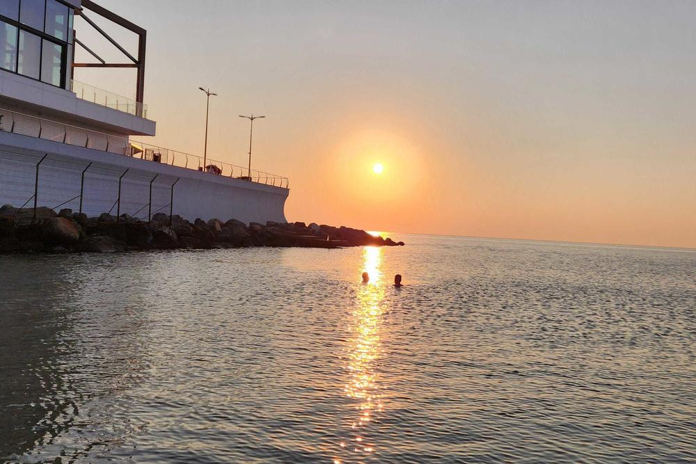 People swim at sunset in Odesa.